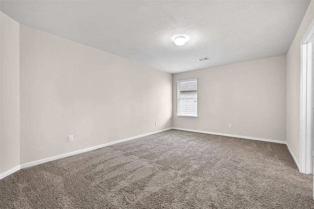 Freshly painted secondary bedroom with plush carpet, large walk-in closet, and direct access to a shared Jack & Jill bathroom.