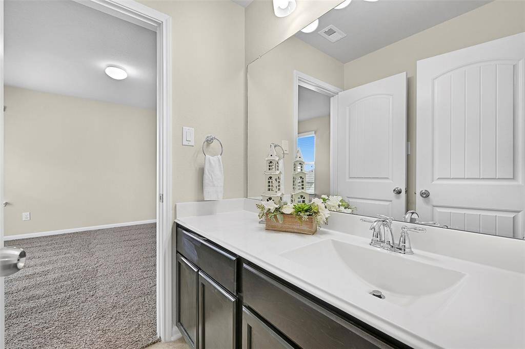 Freshly painted Jack & Jill style bathroom with a spacious vanity, private tub/shower combo, and access from two secondary bedrooms.