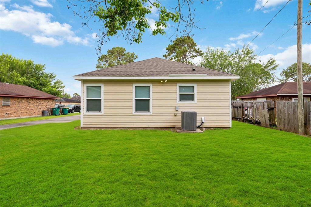 Charming backyard view of this inviting home, featuring a well-maintained exterior and a spacious green lawn, perfect for outdoor living and relaxation.