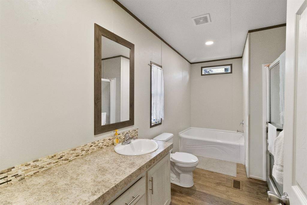 The primary bathroom features a spacious vanity, modern fixtures, and a separate soaking bath and walk in shower.