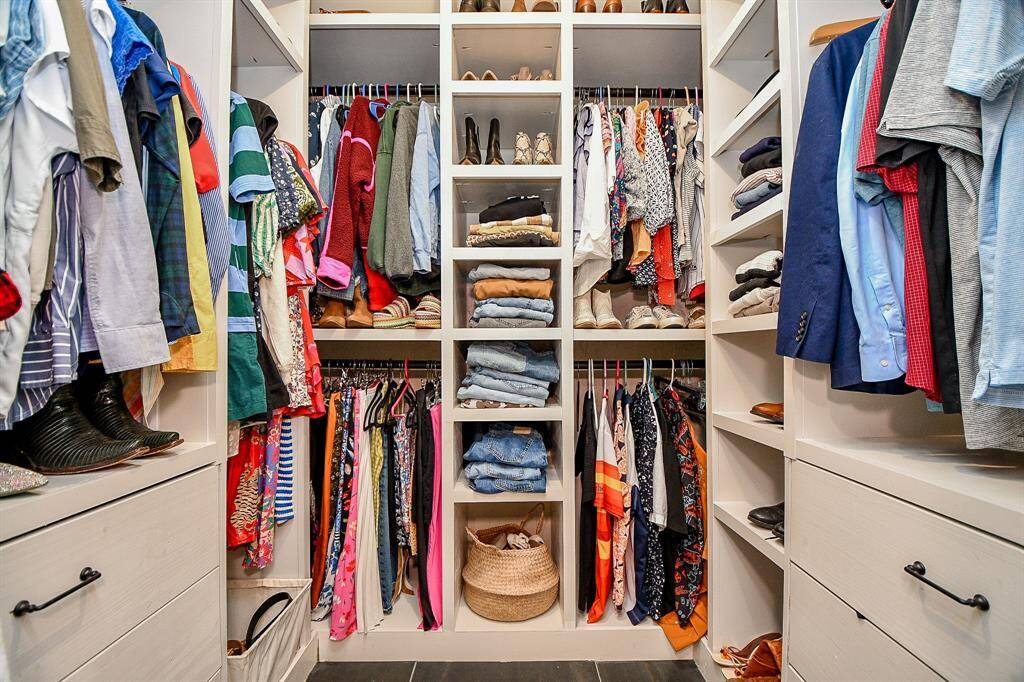 This photo showcases a spacious, well-organized walk-in closet featuring ample hanging space, shelves for folded clothes, and drawers for storage. Ideal for keeping your wardrobe tidy and accessible.