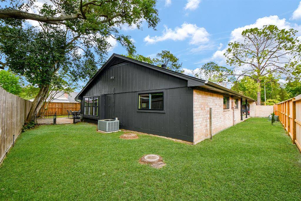 Charming single-story home with a modern black and brick exterior, set on a spacious, well-maintained lawn. The backyard is fenced, providing privacy and includes a patio area for outdoor relaxation. Ideal for families seeking a cozy and stylish living space.