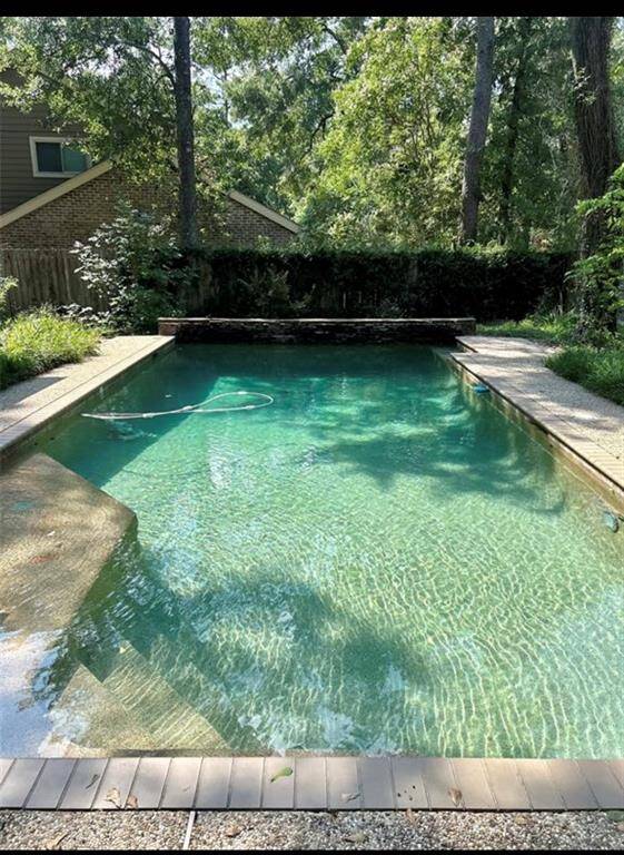 Heated pebble tech bottom pool in a nature scene