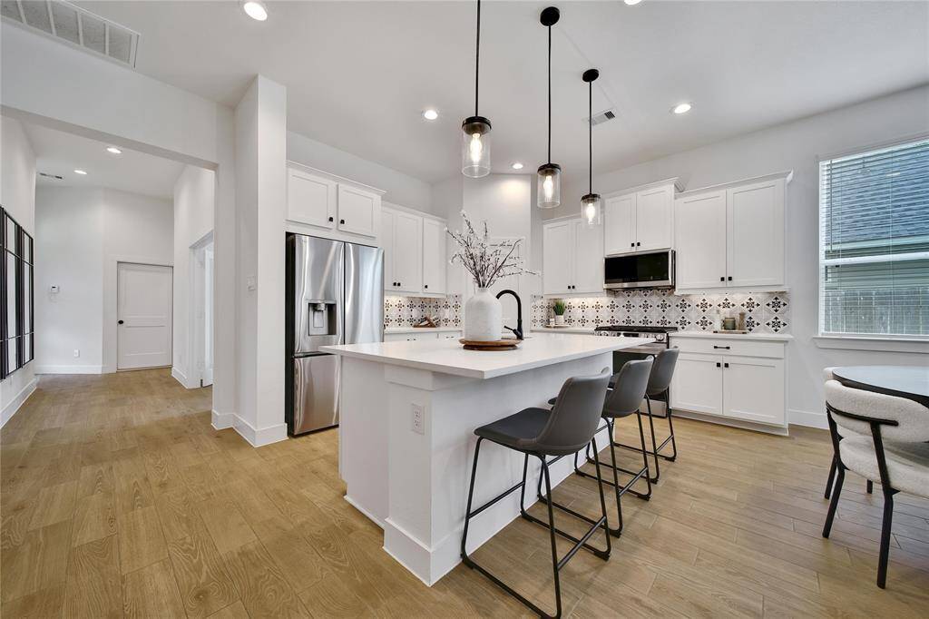 The gourmet kitchen is a dream with the large Symphony White Quartz island that's perfect to gather around.