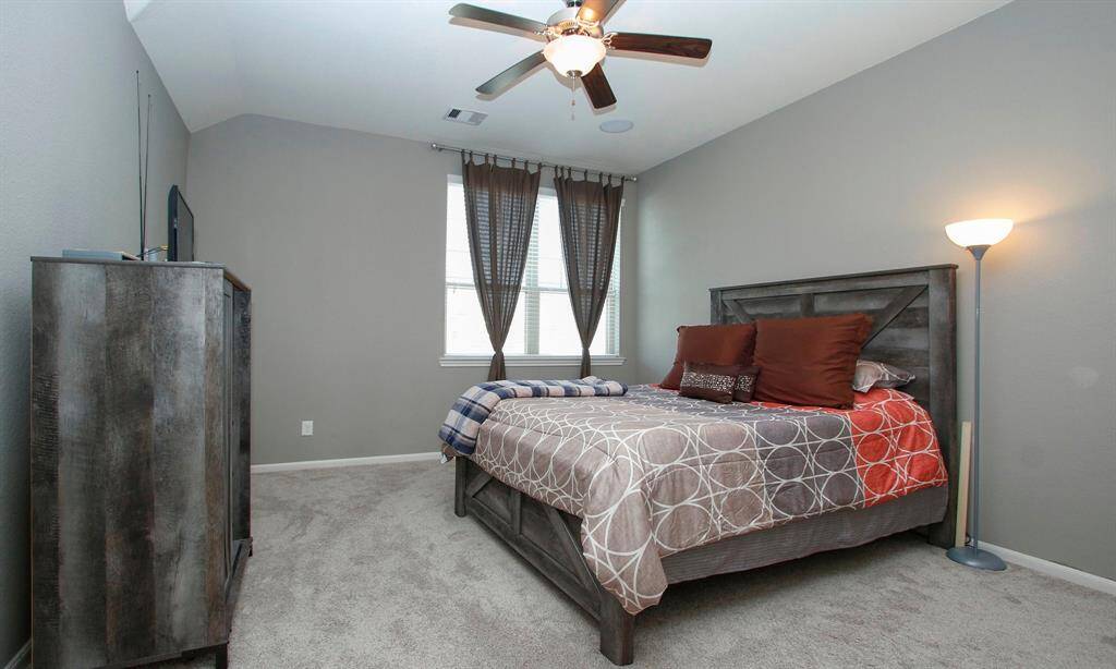Primary bedroom is just off the family room.   High ceilings, ceiling fan and plush carpet makes this a true retreat.