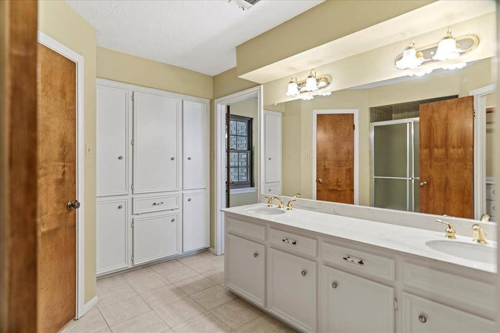 Primary bathroom with his and her walk-in closets