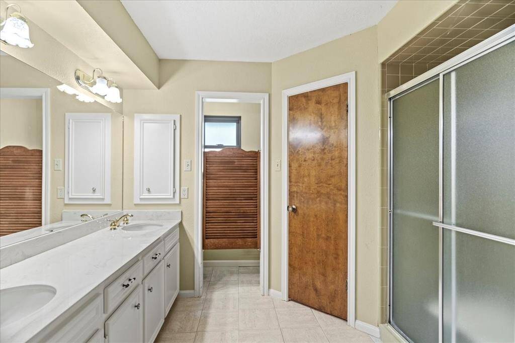 Primary bathroom with his and her walk-in closets