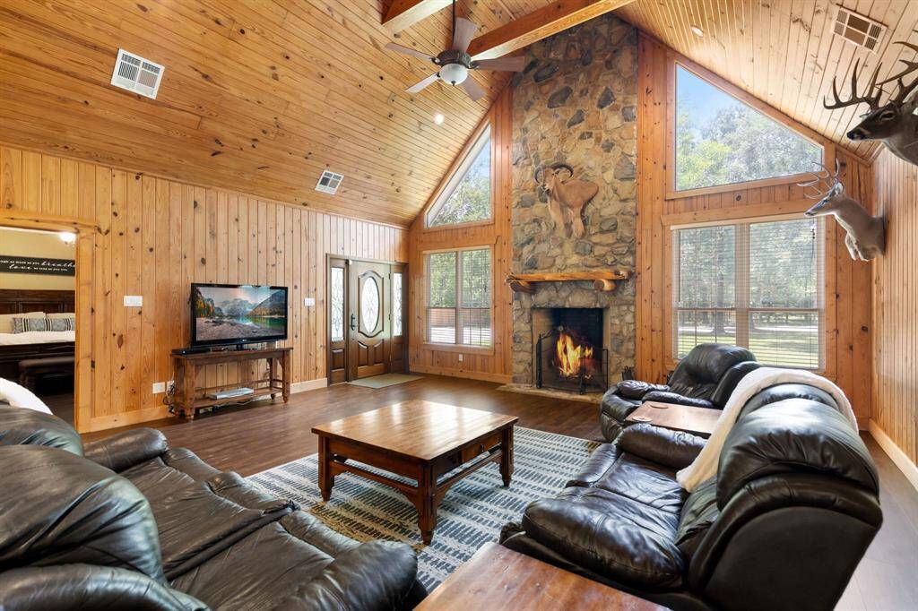 Look back at the entry as well as the stone wood burning fireplace. Huge room with tons of natural light.