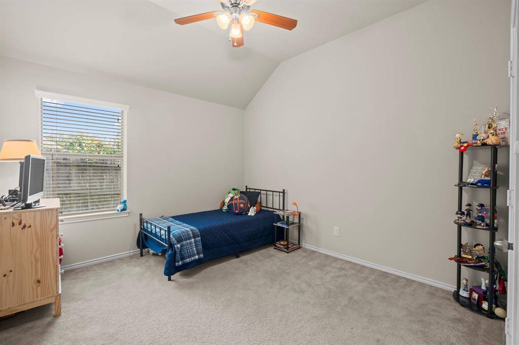 This secondary bedroom features ample natural light and generous space, providing a comfortable and inviting environment adaptable to a variety of uses.