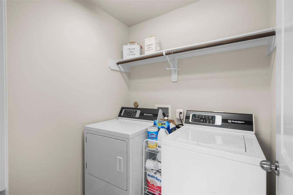 The spacious laundry room provides plenty of room for laundry tasks and includes built-in shelving for convenient storage and organization.
