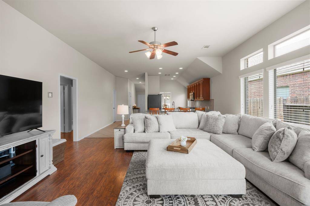 Gather, relax, and make memories in this spacious living room featuring soaring ceilings, abundant natural light, and a seamless flow to the dining and kitchen areas.