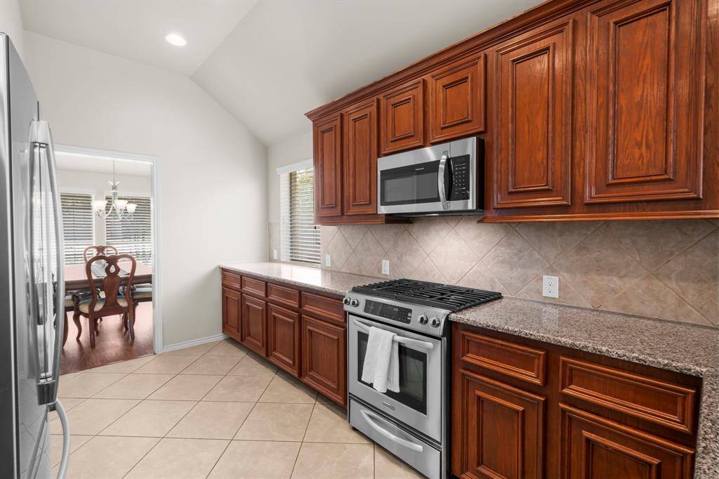 Abundant counter space makes this kitchen ideal for meal prep and entertaining, while the seamless flow into the adjacent dining room adds to the home's open and functional layout.
