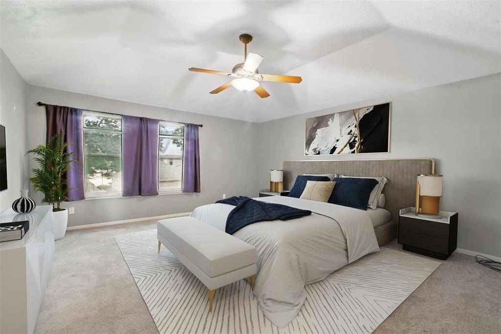 Large primary bedroom features ensuite with generous walk-in closets, offering comfort and convenience. Photo has been virtually staged.