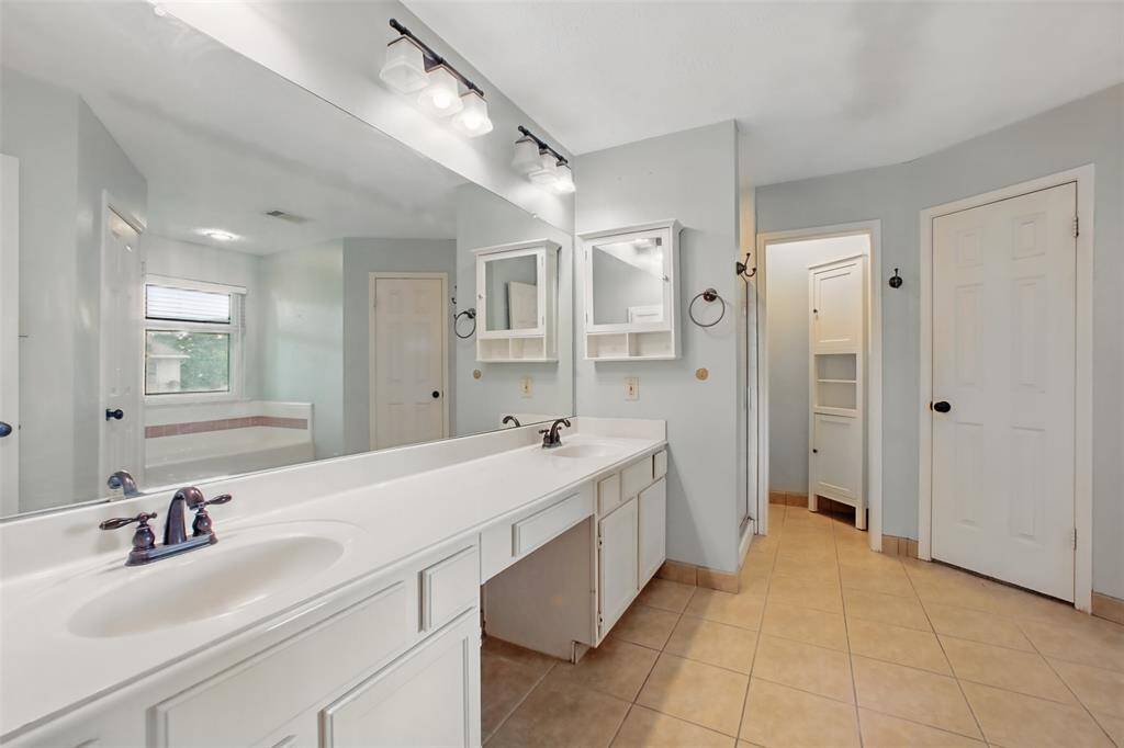 Primary ensuite with dual sinks, vanity area, a large soaking tub and separate shower.