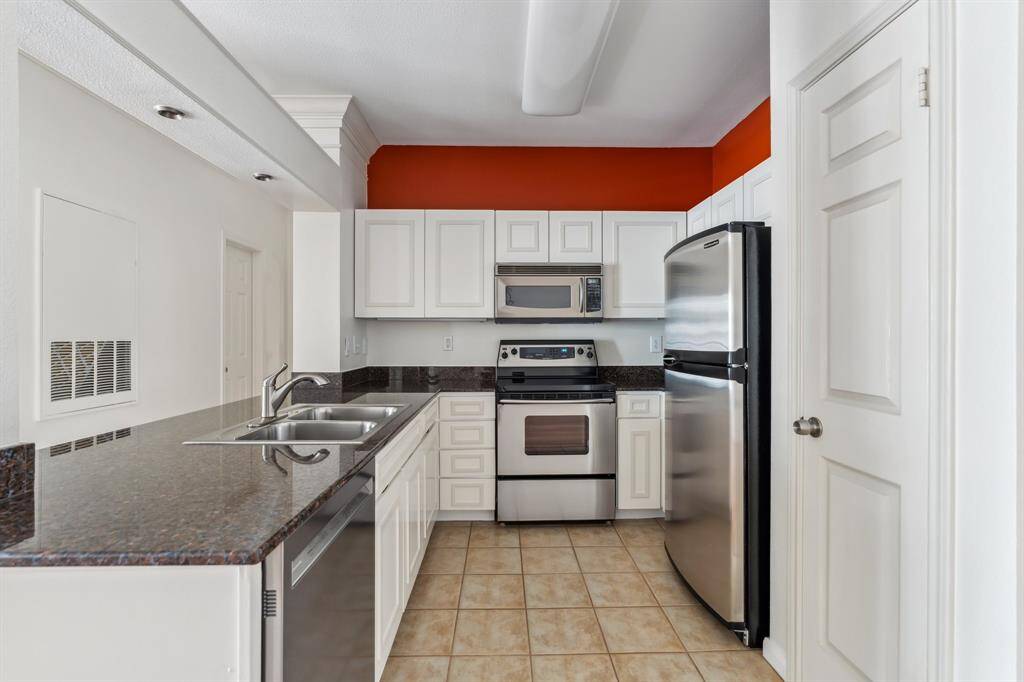 Updated kitchen featuring custom cabinet fronts, granite countertops, and stainless appliances. Efficient layout with pantry and breakfast bar.