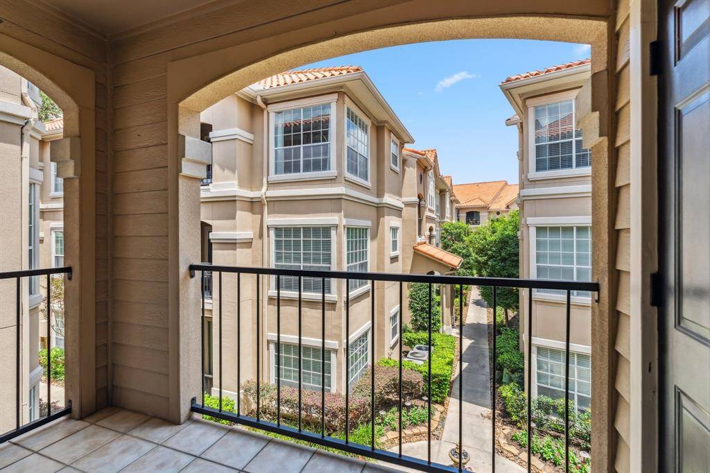 Private balcony with tree-lined views and no direct view into other units. Features outdoor storage closet and space for seating.