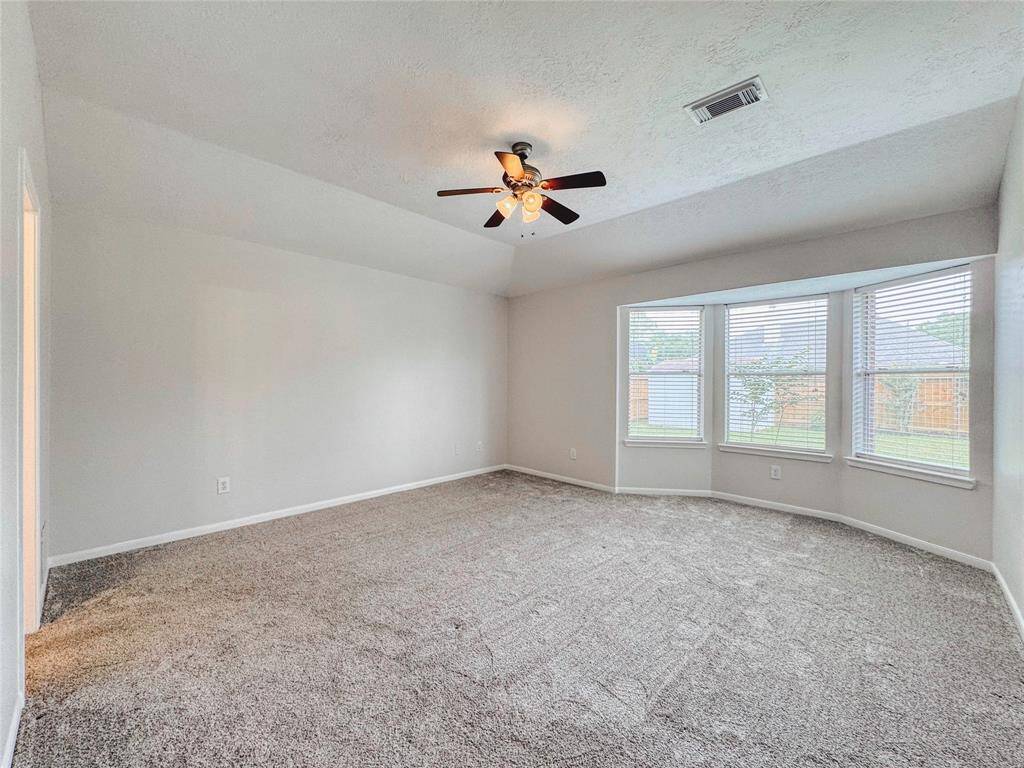 Primary bedroom with bay windows, double sinks, tub/shower combo and large walk-in closet