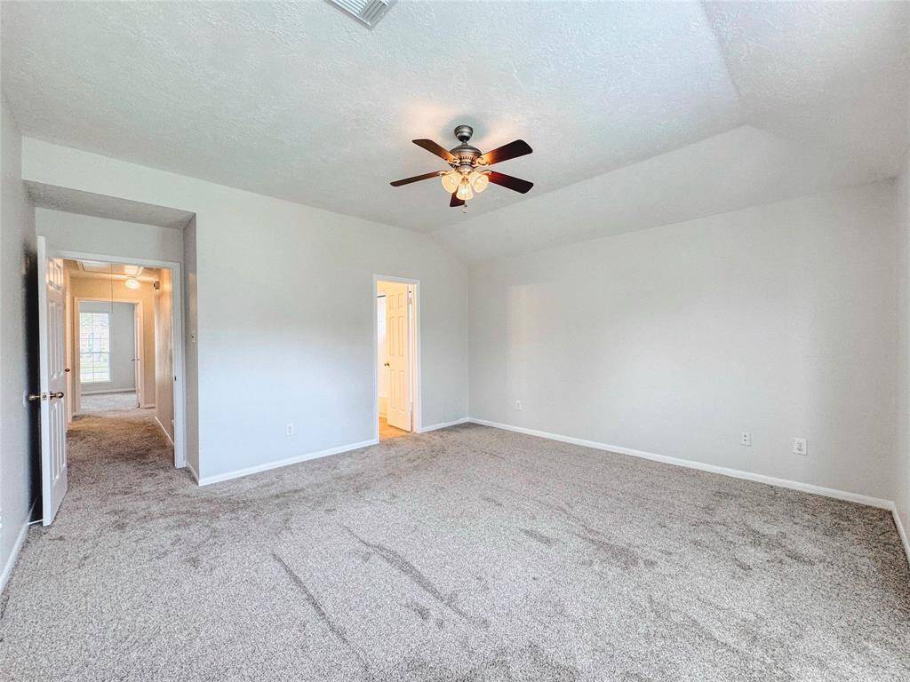 Primary bedroom with bay windows, double sinks, tub/shower combo and large walk-in closet