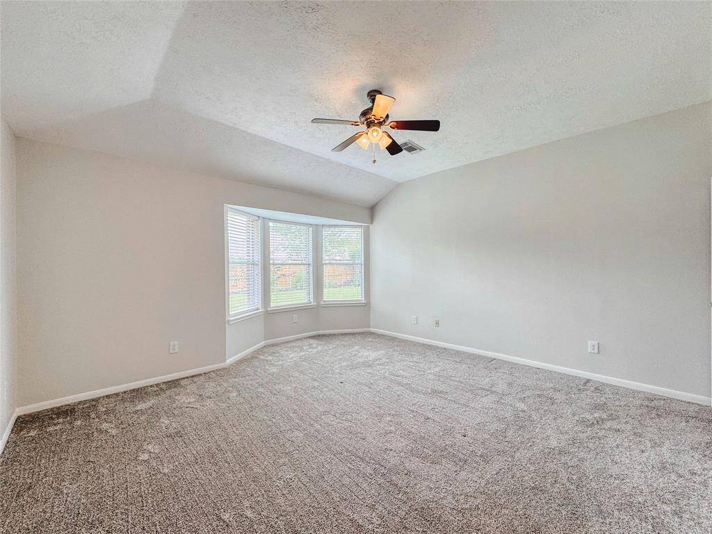 Primary bedroom with bay windows, double sinks, tub/shower combo and large walk-in closet