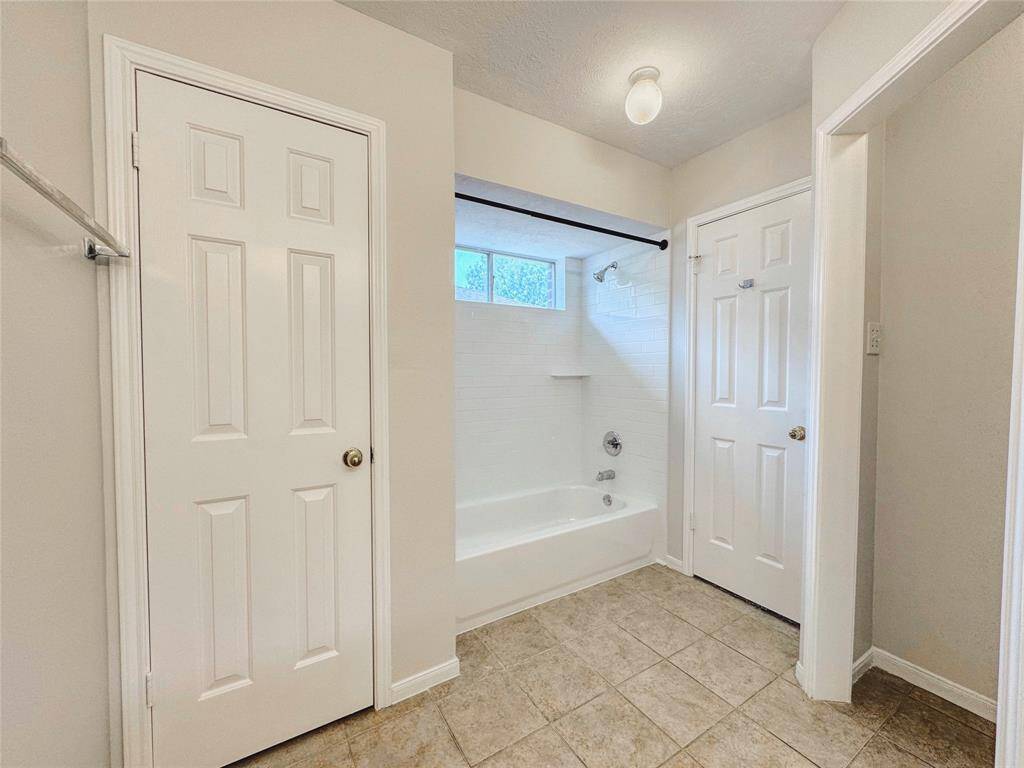Primary bedroom with bay windows, double sinks, tub/shower combo and large walk-in closet