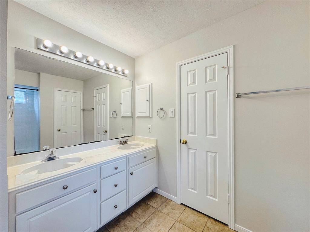 Primary bedroom with bay windows, double sinks, tub/shower combo and large walk-in closet