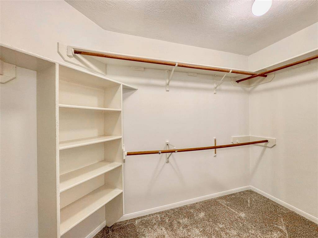 Primary bedroom with bay windows, double sinks, tub/shower combo and large walk-in closet