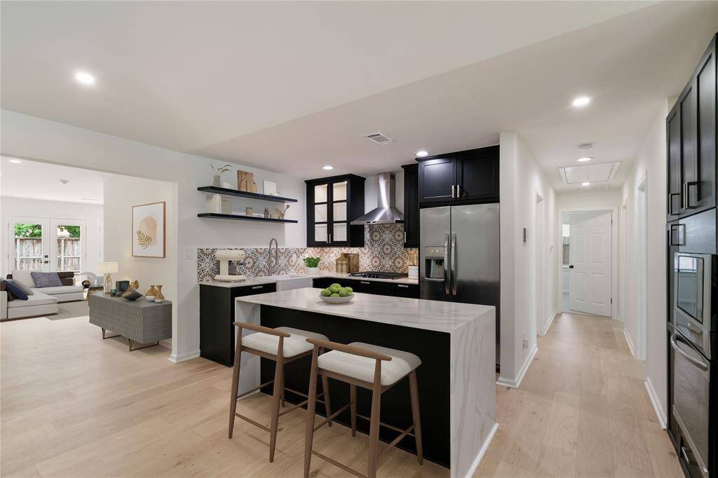 this photo is digitally staged. Kitchen with view of Family Room and Hallway to Secondary Bedrooms