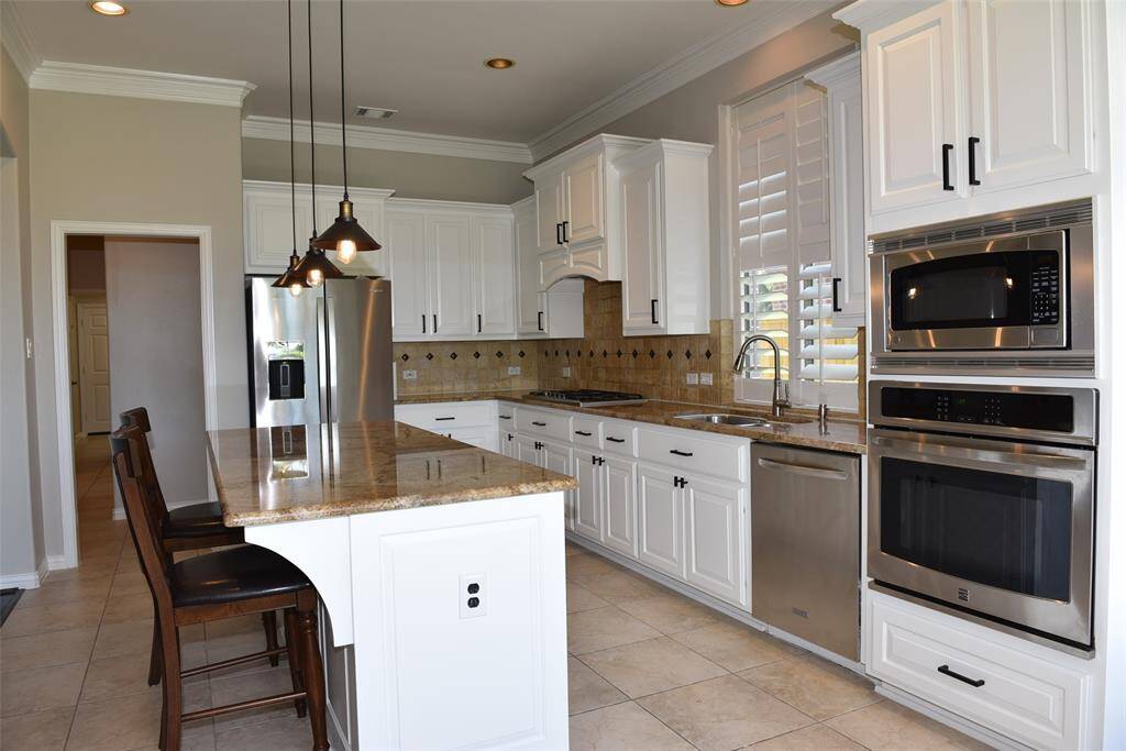 kitchen with granite counter top , island and white cabinets