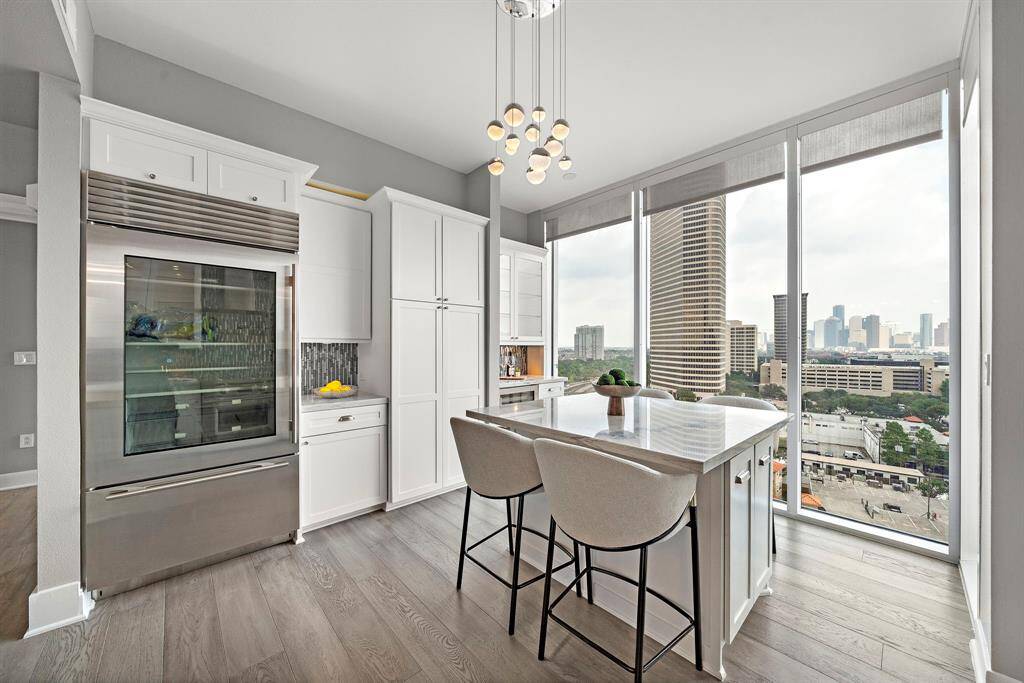 Tucked into a sunlit corner, the casual dining nook offers a cozy vantage point surrounded by panoramic glass and modern built-ins.
