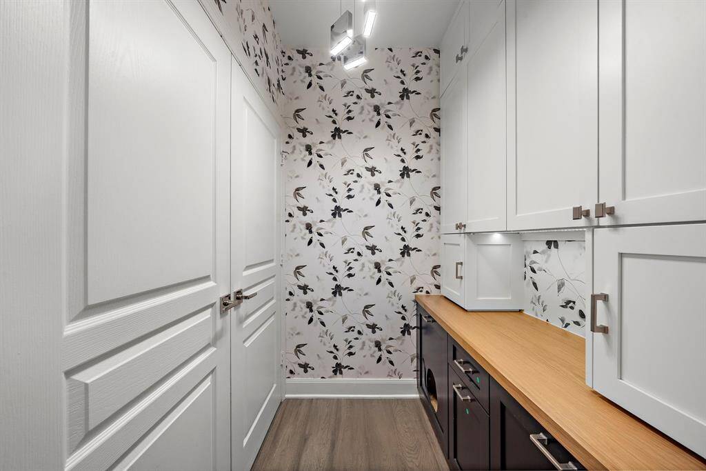 On the opposite wall, full-height cabinets and an extended work surface provide smart storage and task space tucked behind closed doors.