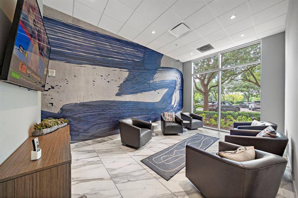 A modern resident lounge offers a relaxed spot to read, recharge, or catch a quiet moment, with oversized windows that bring in natural light.