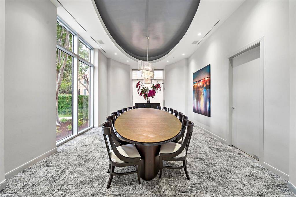 A formal dining room offers a refined setting for intimate dinners or meetings, complete with high-end finishes and garden-facing windows.