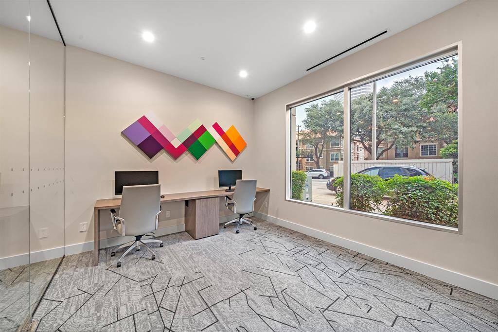 The business center includes dual workstations and street-level views, ideal for remote work or focused productivity.