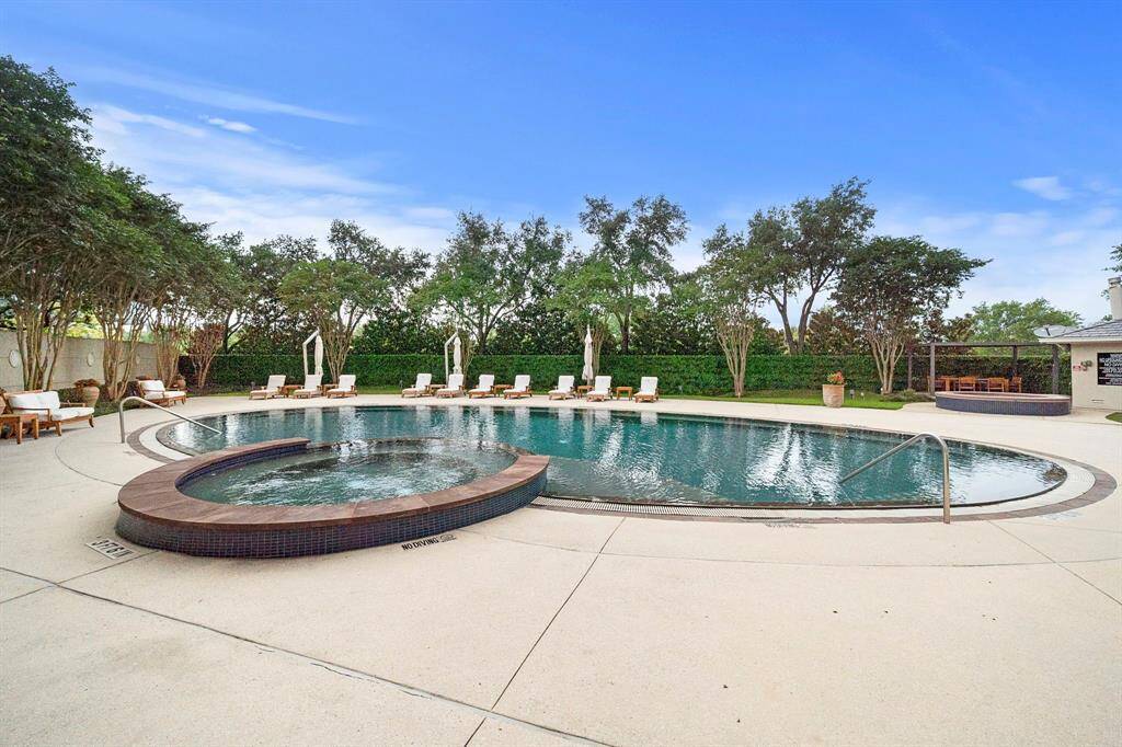 Curved lines frame the pool’s circular design, with umbrellas and seating spread along the perimeter for comfortable relaxation in any season.