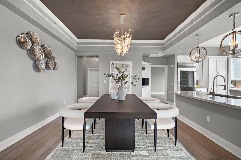 Framed by custom ceiling trim and crisp architectural lines, the dining area offers a warm, inviting transition from entry to entertaining space.