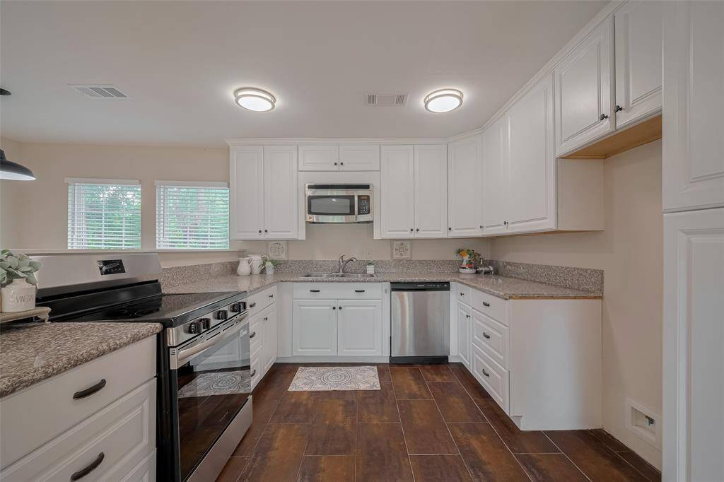 This kitchen has a new electric oven, solid surface counters, microwave and dishwasher.