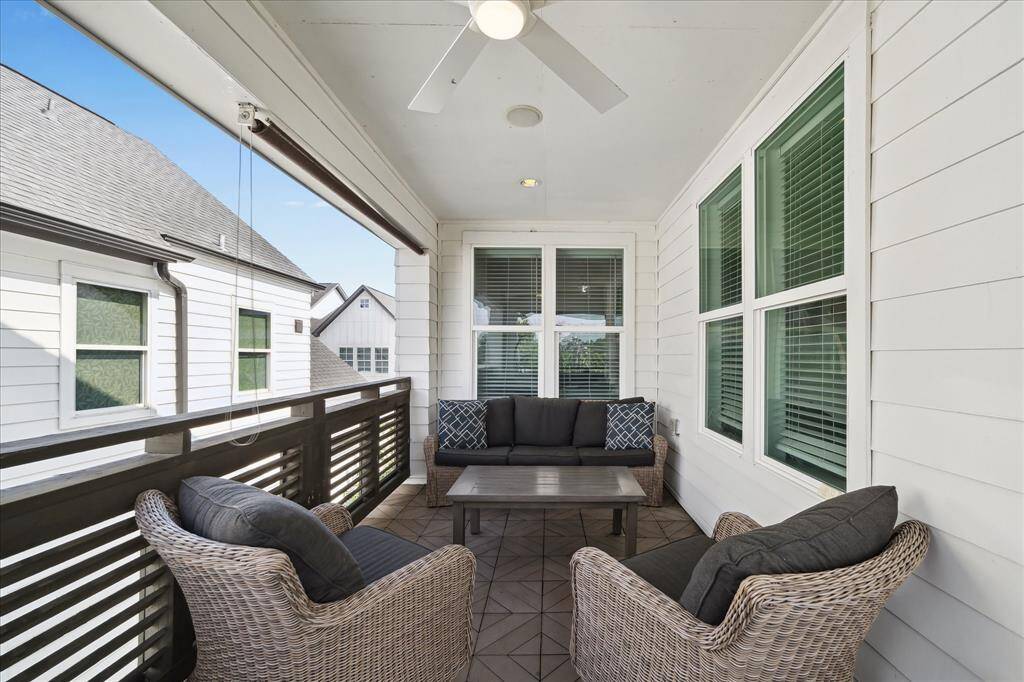 Unwind on the spacious rear balcony, perfect for lounging or entertaining, complete with ceiling fan and privacy shades for year-round comfort.