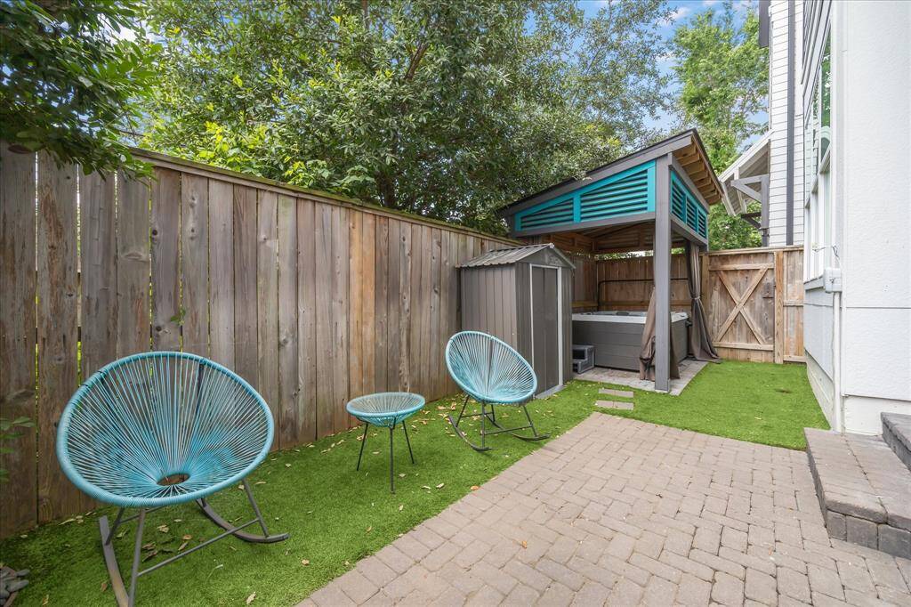 This private outdoor space includes a modern gazebo-covered jacuzzi, ideal for year-round relaxation, plus a storage shed for added convenience.