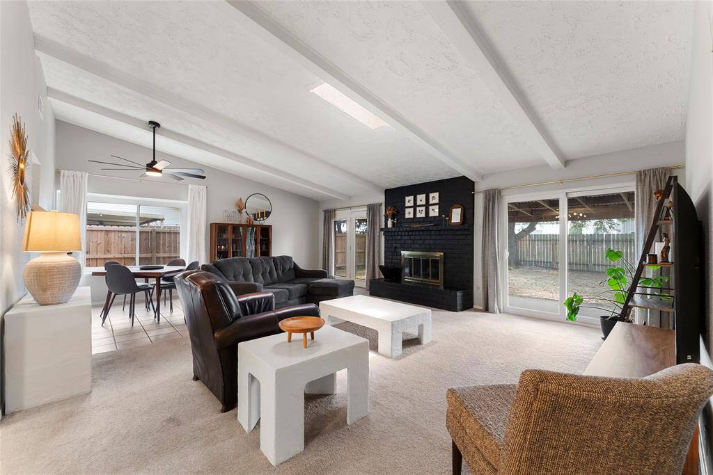 The Living room features high ceilings, updated fan, sky light, double paned windows and sliding doors to the back patio.