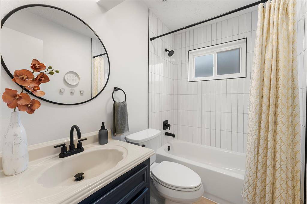 The secondary bathroom with updated shower tiles and fixtures.