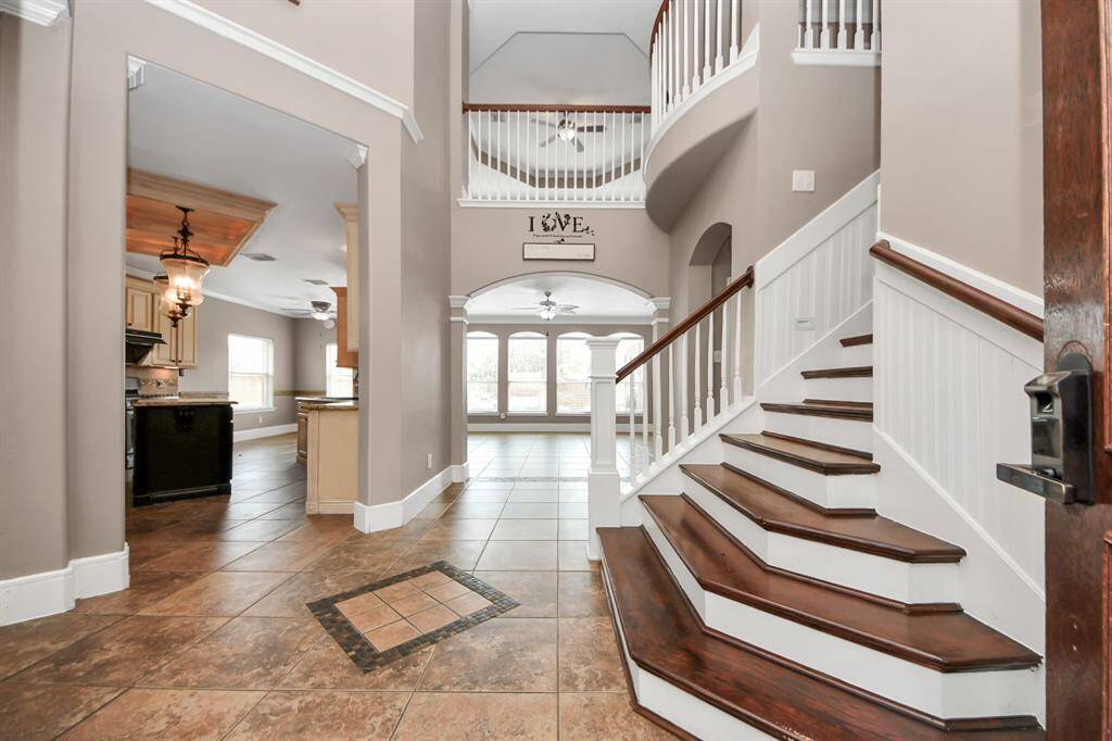 Stunning 2 story high ceiling entry with hard stained cherry solid oak floor steps.