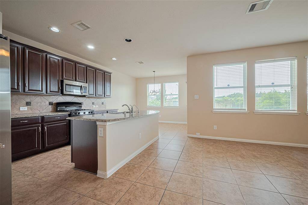 Gather with loved ones in this spacious kitchen offering abundant storage and a sunny breakfast nook—perfect for everyday moments and special occasions.