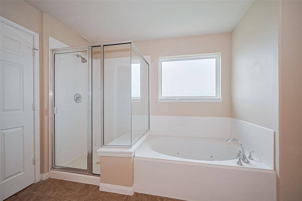 The en-suite bath offers the best of both worlds—soak in the garden tub or refresh in the separate glass-enclosed shower.