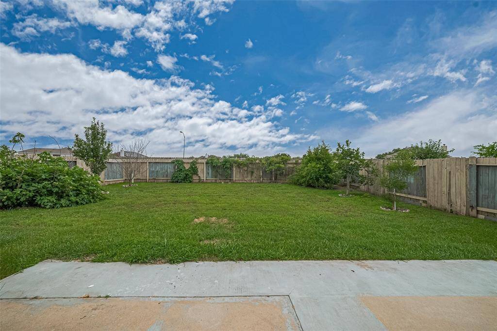 This generously sized backyard offers ample space for outdoor living, gardening, or even a future pool.