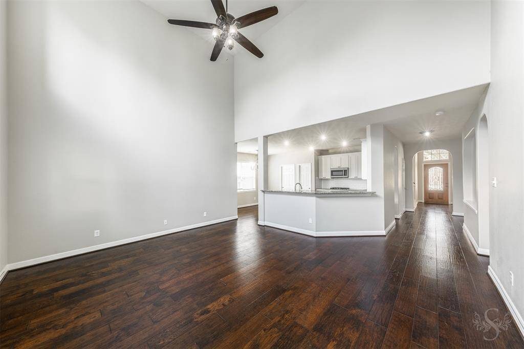 Standing in the living room, you are enveloped by a sense of warmth and sophistication, with wood floors setting the stage for this inviting space. The living room, designed for comfort and style.