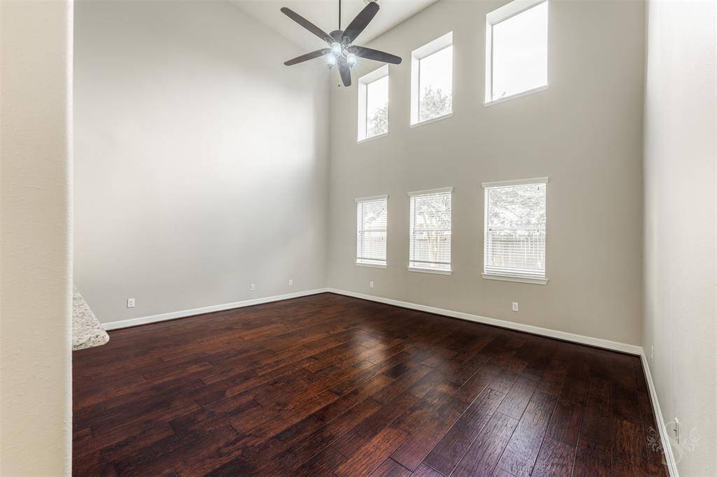 The windows themselves are elegantly dressed with subtle treatments that can be adjusted to filter the light as desired, offering both privacy and unobstructed views. This living area becomes a sanctuary of light and openness, perfectly suited for both intimate gatherings and peaceful solitude.
