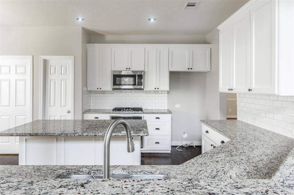 The kitchen is designed for both culinary adventures and casual gatherings, with ample counter space and state-of-the-art appliances. A island stands at the center, providing additional workspace and a casual dining area.