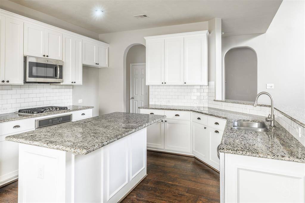 The granite countertops add a touch of luxury with their polished surface and intricate natural patterns, offering both durability and beauty. These countertops provide generous workspace for cooking and entertaining, making the kitchen a true hub of activity.