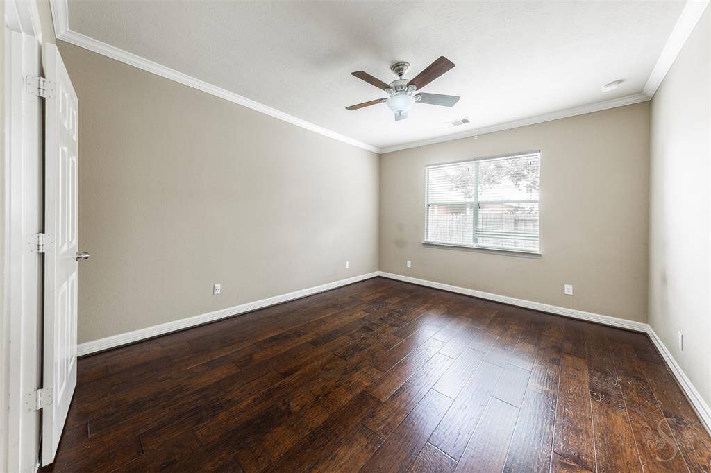 The primary bedroom is a serene retreat, exuding warmth and tranquility through its refined design. The rich hickory wood floors provide a stunning foundation, their natural grain and deep tones creating a sense of warmth and elegance that permeates the space.