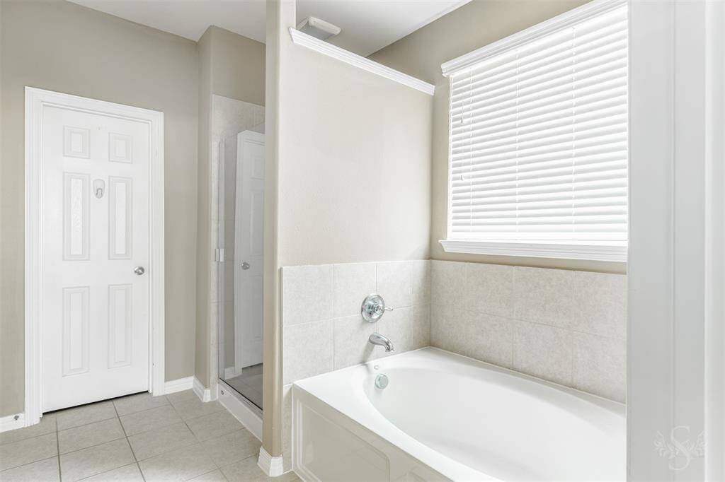Additional features such as a spacious walk-in shower and a separate soaking tub further enhance the room's luxury, offering a variety of options for relaxation and rejuvenation. The primary bathroom stands as a testament to thoughtful design, providing a personal retreat that combines style, comfort, and functionality in perfect harmony.